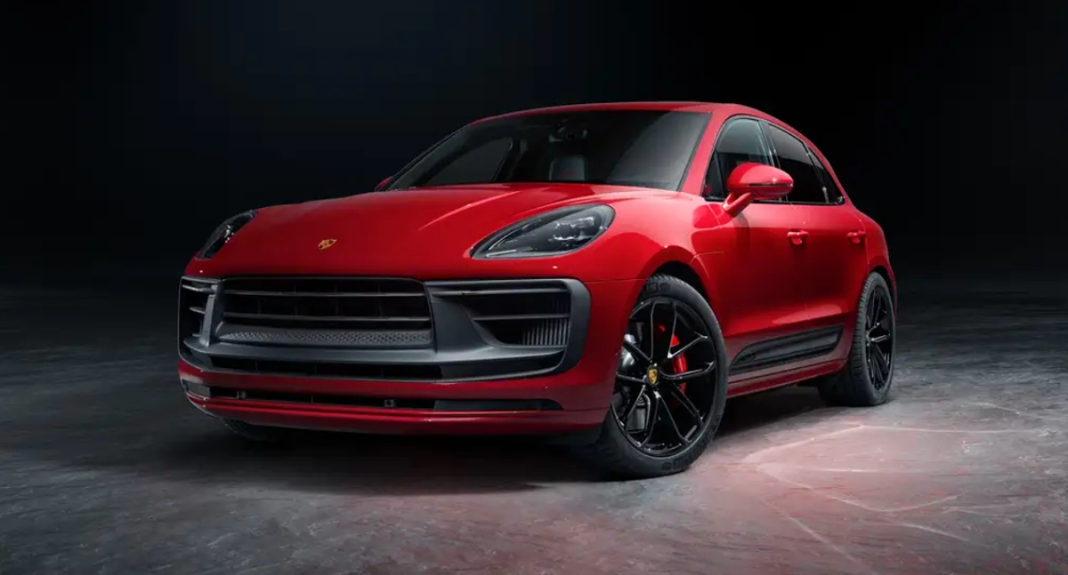 A small red 2023 Porsche Macan luxury SUV is parked.