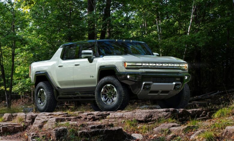 A green 2023 GMC Hummer EV electric pickup truck is parked outdoors.