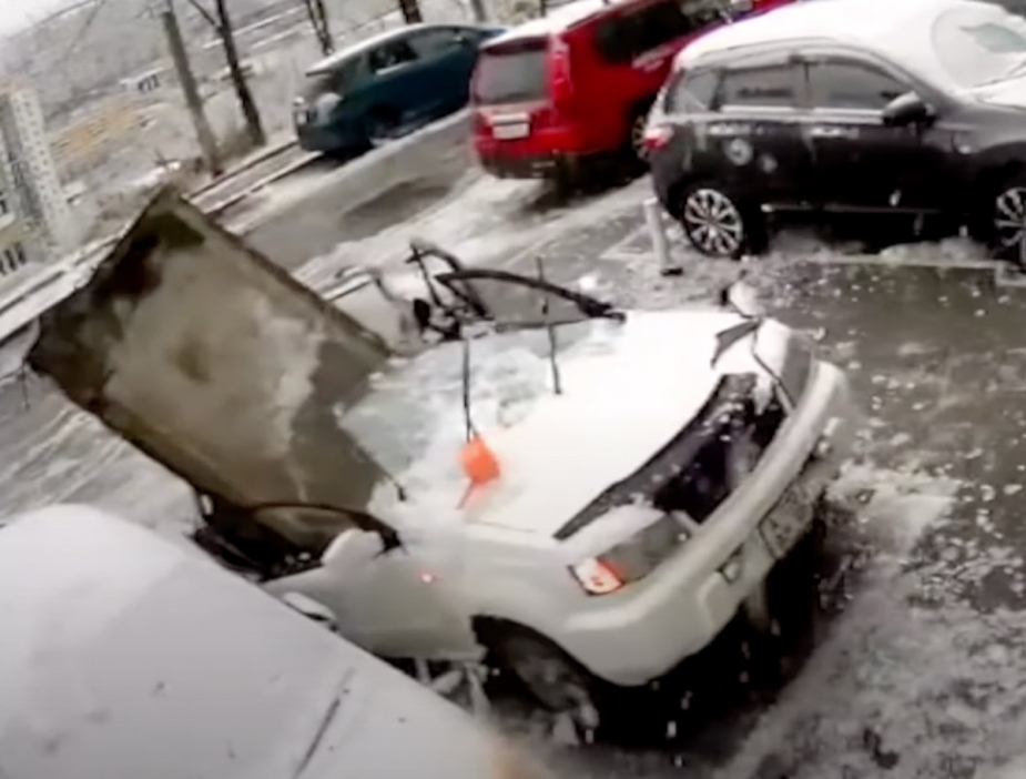 In a viral YouTube video from Russia, a large concrete slab is erected in a destroyed car after it fell from the building.  