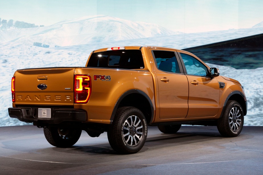 An orange 2019 Ford Ranger midsize truck parked at an auto show.