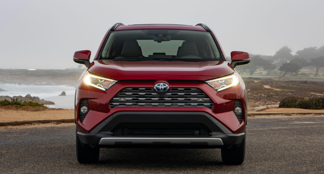 A red 2019 Toyota RAV4 Hybrid small SUV is parked.
