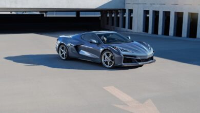 The new hybrid electric Corvette E-Ray poses for a picture in a parking lot, showing off its front end.