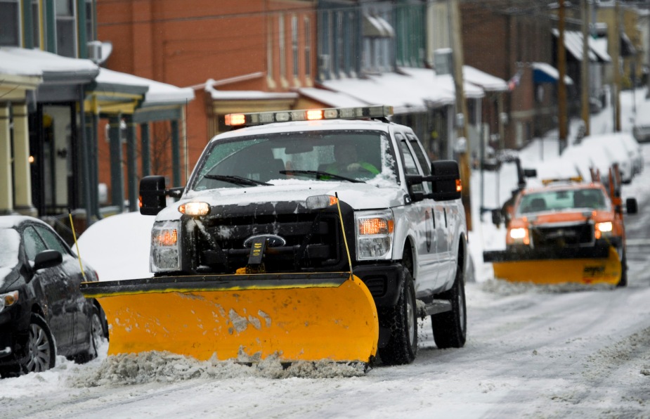 A Ford diesel truck plows the main street of a small town on a cold winter's day.