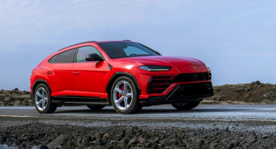 A red 2023 Lamborghini Urus is parked off the street. 