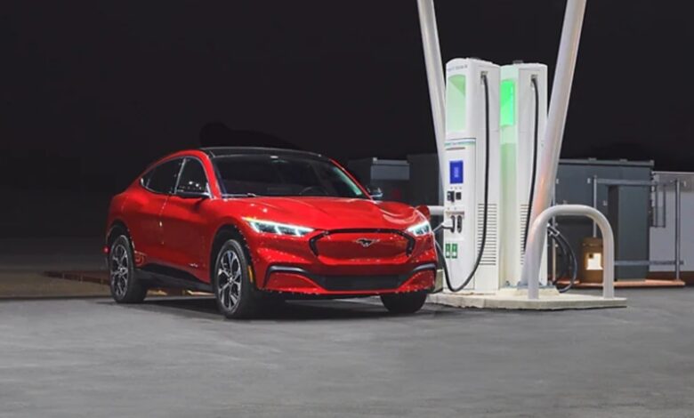 A red Ford Mustang Mach-E small electric SUV is charging.