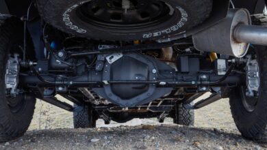 The drivetrain of a 4WD Ram 2500 Power Wagon pickup truck parked on a gravel road, its spare tire visible.