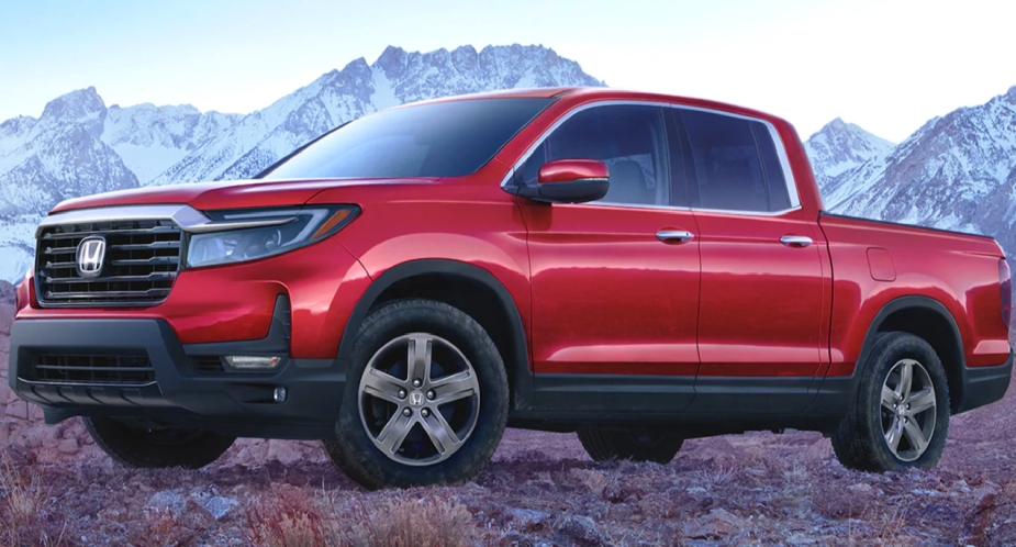 A red 2023 Honda Ridgeline mid-size pickup truck parked outdoors. 