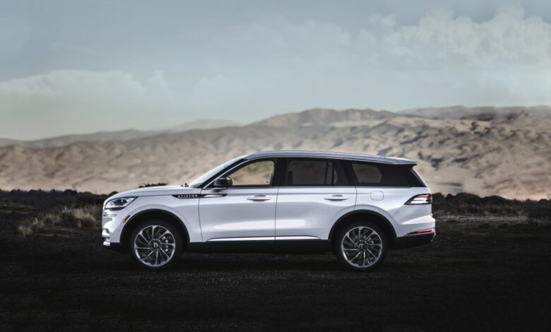 Spacious midsize luxury SUVs like this 2023 Lincoln Aviator parked in front of a mountain