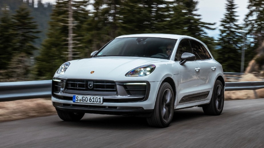 Front angled view of the white 2023 Porsche Macan, the new cheapest Porsche car and the best luxury SUV for car and driver