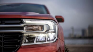 A closeup on the grille and headlights of a red 2022 Ford Maverick Lariat compact pickup truck model