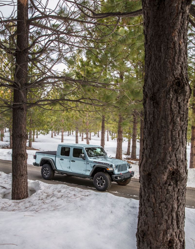 2023 Jeep Gladiator in new Jeep color and Early Gray paint, driving in the woods.