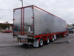 Why do some semi truck trailers have a small door in their main door?