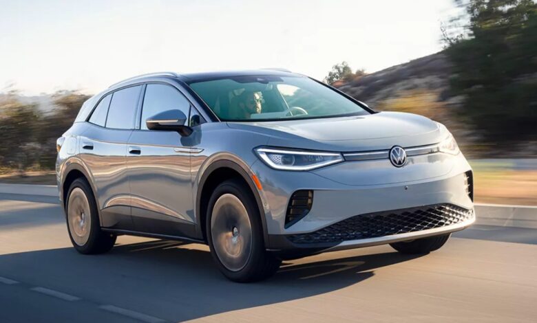 A gray 2023 Volkswagen ID.4 small electric SUV is driving on the road.