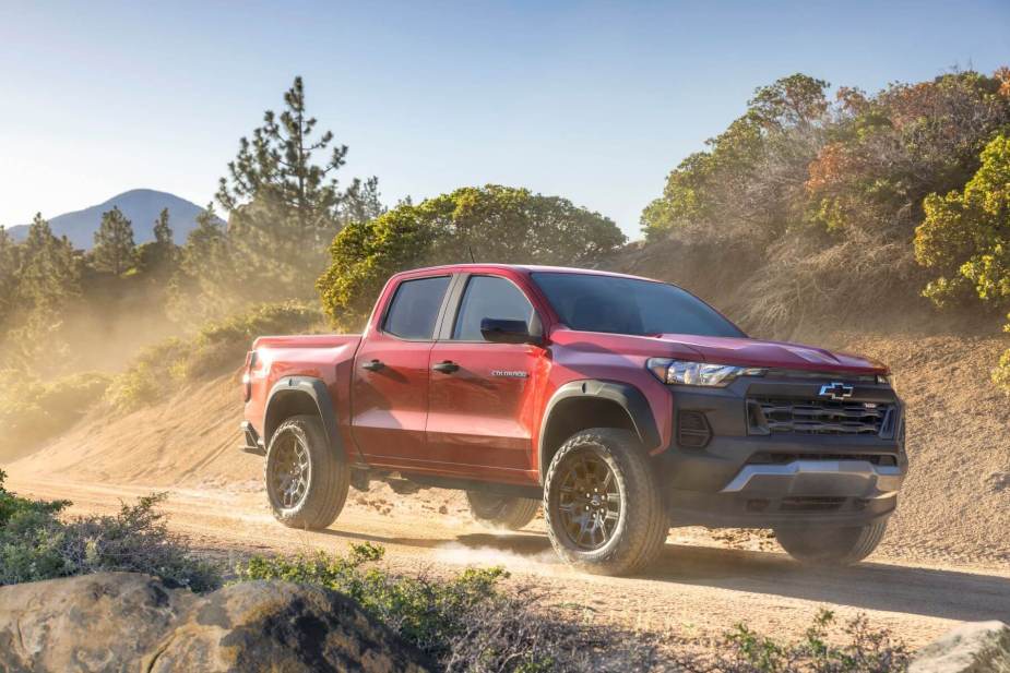 2023 Chevrolet Colorado Trail Boss Red Midsize Pickup Truck Model Driving On A Dirt Wild Road