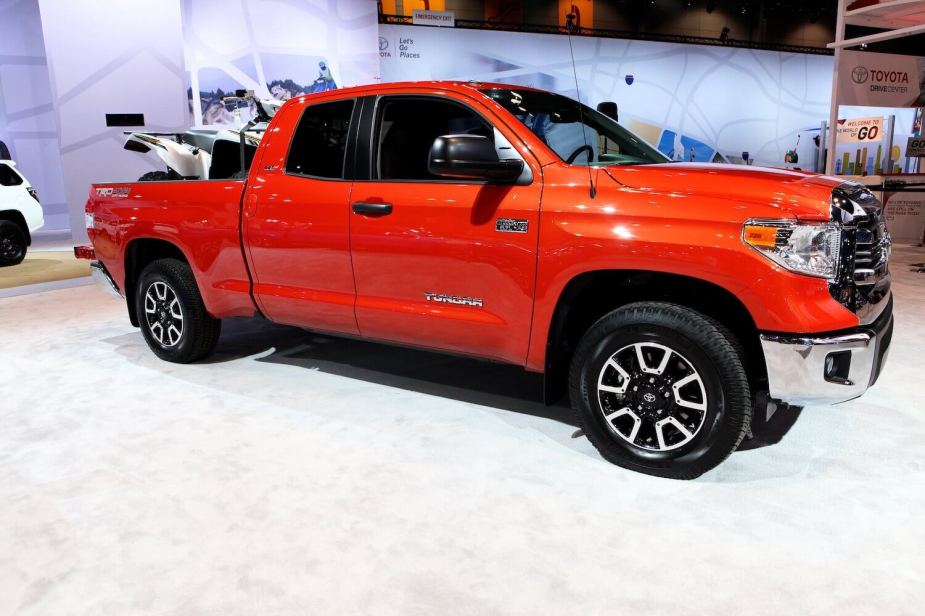 A bright orange 2017 Toyota Tundra on display at a car show.
