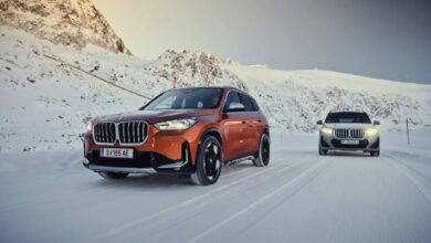 Orange and gray BMW X1 xDrive23d and XDrive30 models driving through the snow near mountains