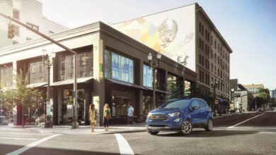 A blue 2022 Ford EcoSport subcompact crossover SUV model stopped at a crosswalk