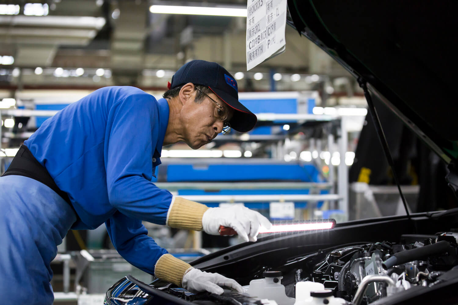A Toyota factory worker inspects the car for the legendary company's reliability.