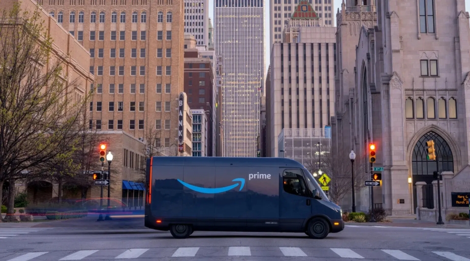 The Rivian Amazon delivery truck shows off its unique design in the city.