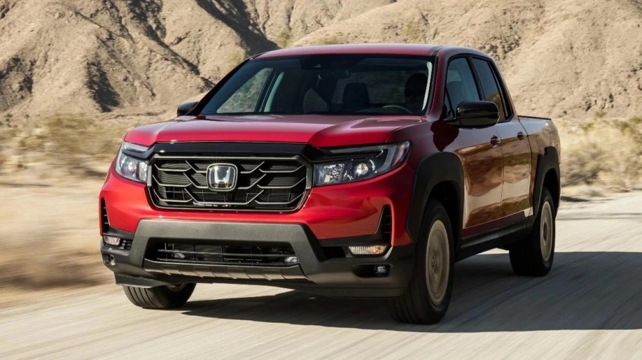 Red corner front view of the 2023 Honda Ridgeline, the best new 2023 mid-size pickup truck to buy, says Car and Driver
