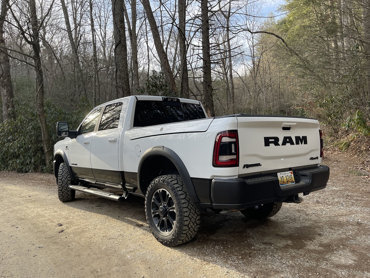 Promotional photo of a white 2023 Ram 2500 HD with cargo boxes inside the bed.