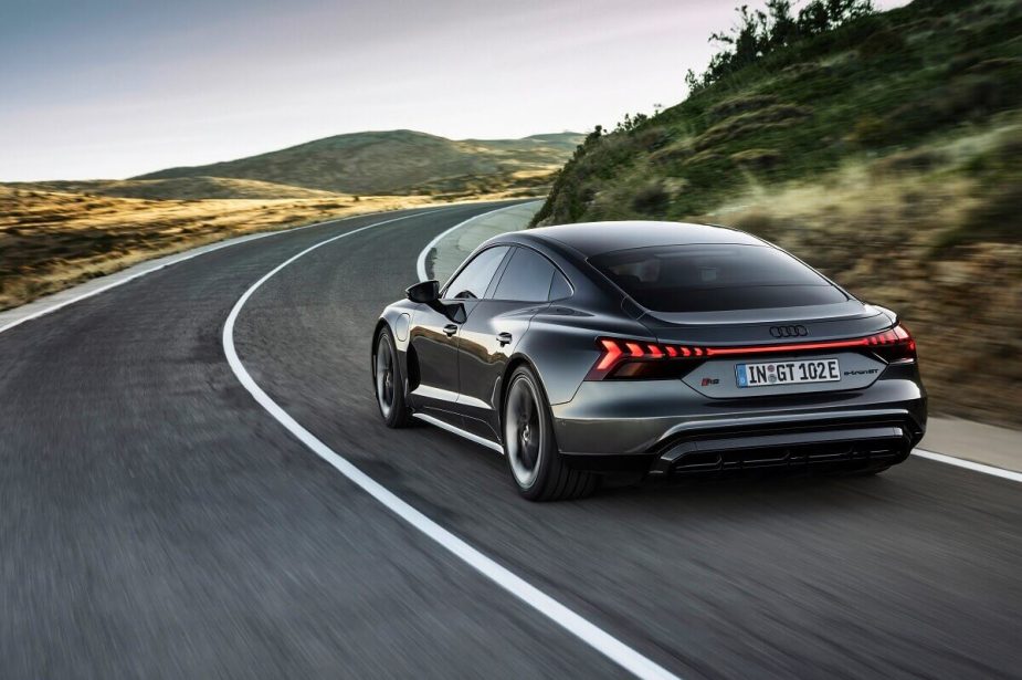 The gray Audi e-tron GT drives down a country road. 