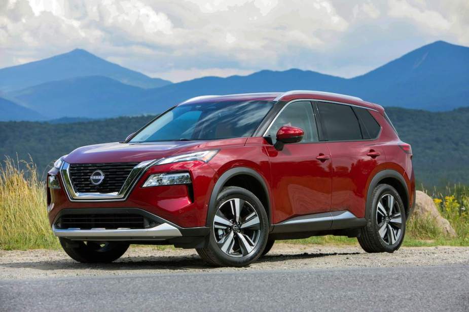 A red 2023 Nissan Rogue is on the road.