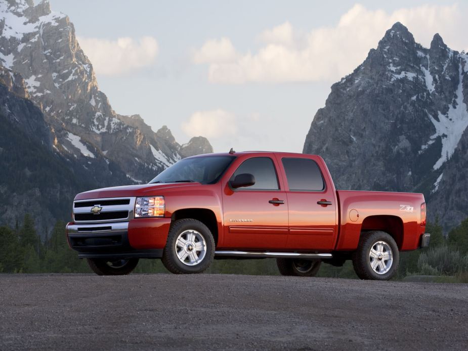A red Chevrolet Silverado parked in front of the mountains.