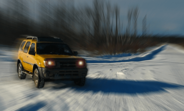 A very stylized picture of a yellow Nissan Xterra in the snow.