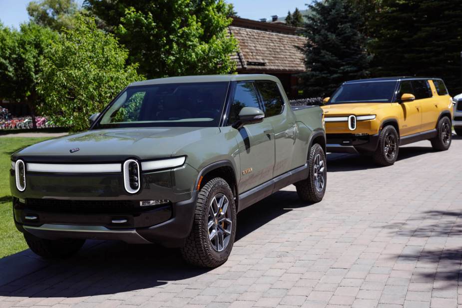 A Rivian R1T electric truck sits on a driveway in the sun.  This model has been affected by a charging station failure. 