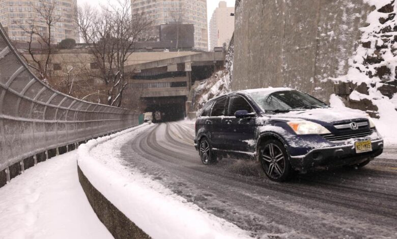 A Honda CR-V climbs a hill amid snowy conditions in an urban setting.