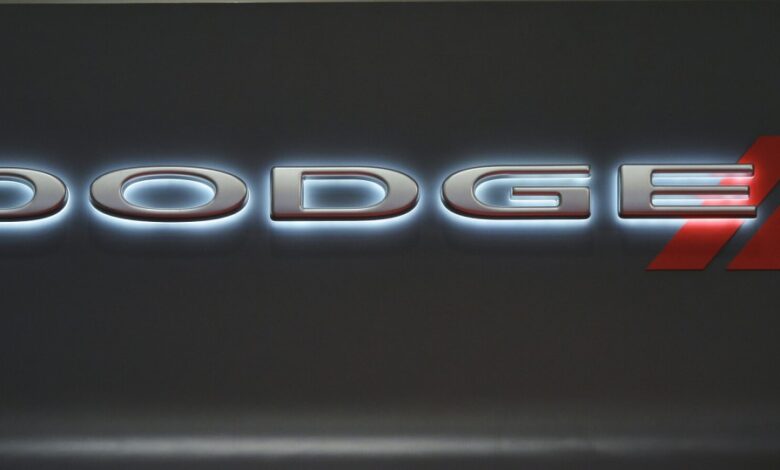 A backlit Dodge logo on a black background.