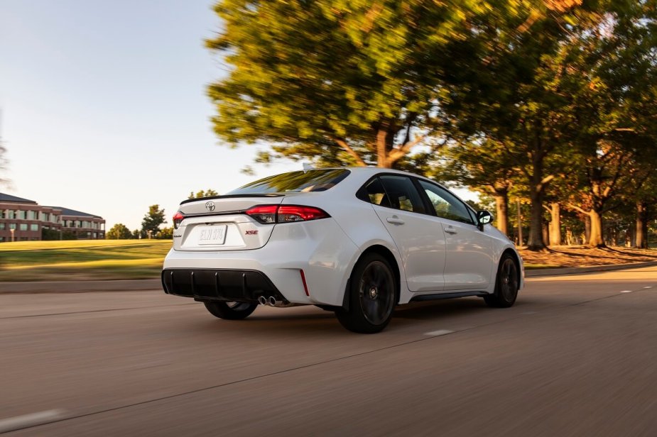 A white 2023 Toyota Corolla is cruising on a country road. 