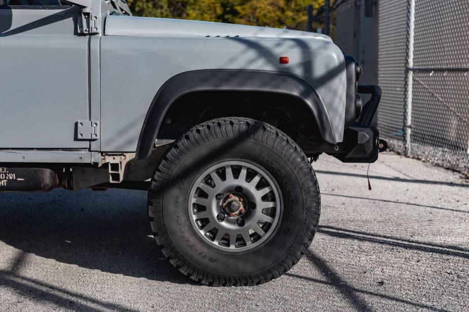 Close-up of the front rim and tire of the Land Rover Defender 6x6 truck.