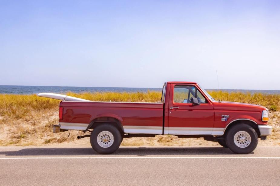 Red Ford F-150 regular or regular cab pickup truck with only one row of seats.