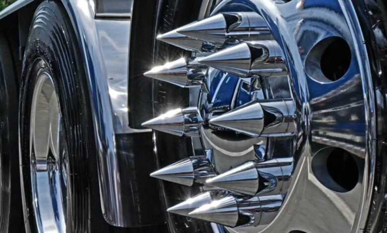 Closeup of the chromed lug nut cover spikes on the wheel of a semi truck.