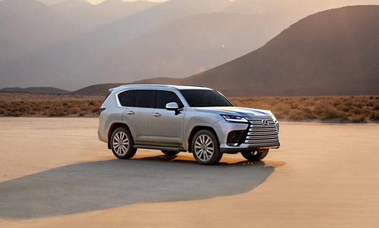 The 2023 Lexus RX sits in golden light with mountains in the background.
