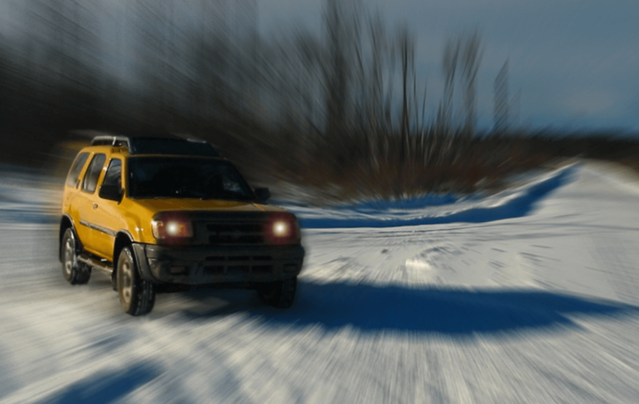 A very stylized image of a yellow Nissan Xterra in the snow. 