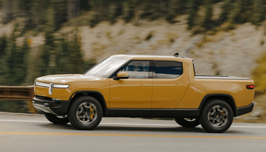 2022 Rivian in yellow, driving through a canyon. 