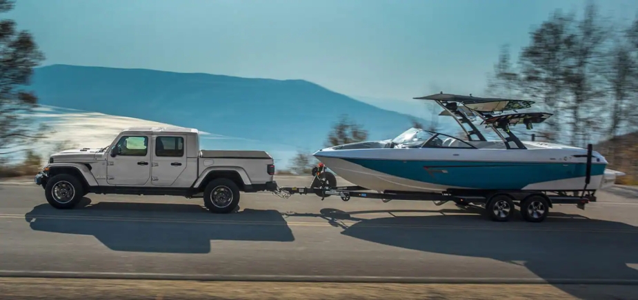 2023 Jeep Gladiator towing a boat.  It is the last mid-size pickup truck with a diesel engine.